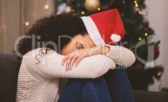 Silent night and Christmas just doesnt feel right. Shot of a young woman looking sad during Christmas at home.