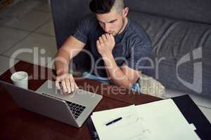 Hes got the discipline to work from home. Shot of a driven young man using his laptop to work from home.