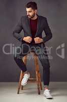 His confidence is the first thing everyone notices. Studio shot of a handsome young man posing against a dark background.