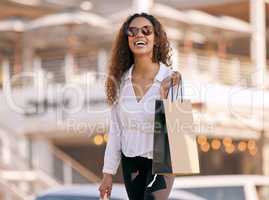 Living life in the designer lane. Shot of an attractive young woman walking alone outside while shopping in the city.