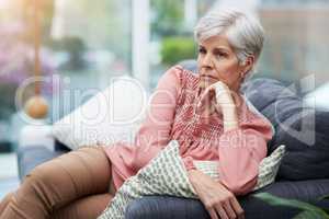 This whole situation Im in is making me angry. Shot of a mature woman looking thoughtful while relaxing on her couch at home.