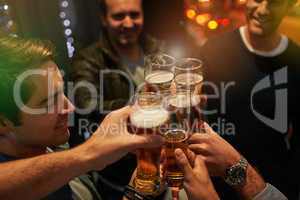 To nights like these. High angle shot of guys toasting with beers at a party.