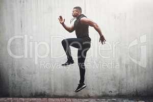 Getting the blood pumping. Full length shot of a handsome young man skipping on the spot while exercising outside.