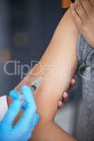 .. Shot of a woman receiving an injection at a Covid-19 vaccination centre.