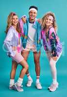 The 80s was one of the most eclectic decades in fashion. Shot of three young people posing together in 80s clothing against a blue background.
