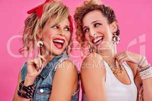 We share a love for 80s fashion. Studio shot of two beautiful young women styled in 80s clothing.