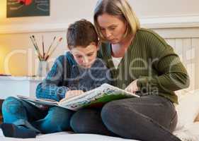 He wants to know all the facts about dinosaurs. Shot of a mother and son reading a book about dinosaurs together in a bedroom at home.