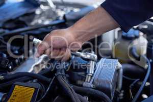 Safety first. High angle shot of an unrecognizable male mechanic working on the engine of a car during a service.