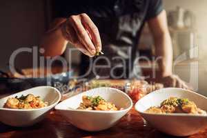 Food as good as the restaurant makes it. Shot of an unrecognisable man preparing a delicious meal at home.