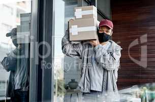 If its lockdown, Ill leave it at your door. Shot of a masked young man delivering a package to a place of residence.