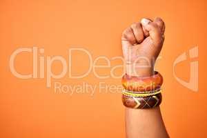 I fight for my rights. Shot of an unrecognizable person holding up a fist against an orange background.