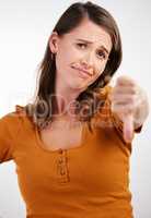 Time to get up for work. Studio shot of a young woman showing thumbs down against a white background.