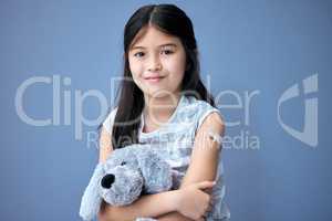 Protecting our children. Shot of an adorable little girl sitting in the studio after getting her Covid vaccine and holding a teddy bear.