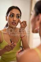 Just a dab of concealer for those dark circles. Cropped shot of a young woman applying makeup in the bathroom.