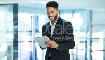 Having a digital tablet makes life more convenient. Shot of a young businessman using a digital tablet.