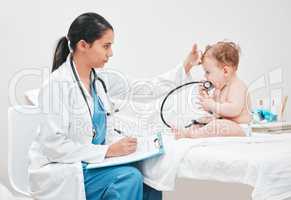Its normal for babies to have a fever when teething. Shot of a paediatrician completing paperwork during a checkup.