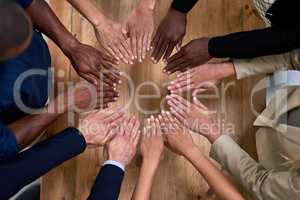Every contribution makes us better. High angle shot of a group of unidentifiable businesspeople making a circle with their hands in the office.