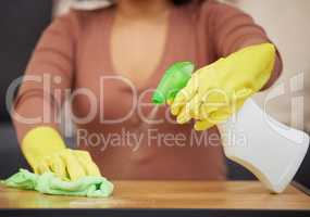 Keeping my tabletops germ-free. Cropped shot of an unrecognizable woman using detergent and a cloth to wipe the tabletops at home.