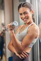 I love a bit of toning. Cropped portrait of an attractive young female athlete working out with a dumbbell in the gym.