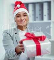 I saw this and thought of you. Portrait of a young beautiful woman spreading Christmas cheer with gifts at the office.