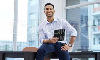 My name will be spoke in rooms globally. Shot of a handsome young businessman sitting alone in his office and holding a digital tablet.