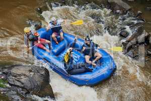 Theres no taming the rapids only going with the flow. Shot of a group of young male friends white water rafting.