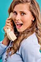 He had me at hello. Studio shot of a young woman holding a telephone while wearing 80s clothing.