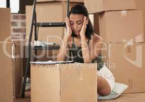 Moving deserves a vacation. Shot of a young woman having a stressful day during packing at home.