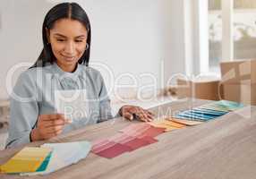 This looks like the winner. Shot of a young woman looking at different colour swatches while renovating her house.