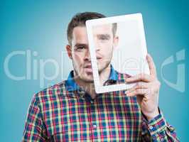 Personalised technology - A part of everyday existance. A young man holding an advanced digital tablet in front of his face.