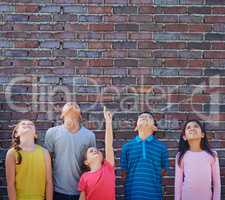 Education will take us higher. Shot of a diverse group of children looking up outside.