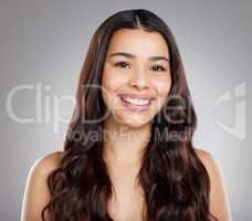 A good hair stylist is a sheer delight. Studio portrait of an attractive young woman posing against a grey background.