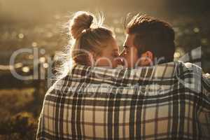 This moment is quite special. Shot of an affectionate couple wrapped in a blanket while spending time out in nature.