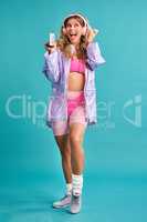 This is my favourite jam right here. Studio shot of a young woman holding a cassette player while dressed in 80s clothing.