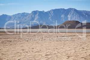 Miles of emptiness. Shot of a desolate landscape during the day with a small dried out dam in the middle.