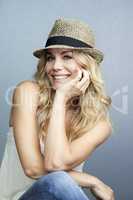 Carefree summer style. Portrait of a beautiful woman wearing a straw hat giving you a toothy smile.