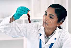 Soon well know whats in this blood. Cropped shot of an attractive young female scientist inspecting a test tube filled with blood while working in a laboratory.