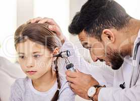 The Doctor is checking my ears today. Shot of a doctor using an otoscope to examine a little girls ear.