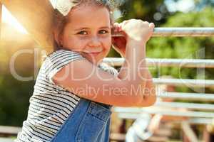 Playtime is the best time. Portrait of a little girl playing on the jungle gym at the park.