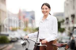 Doing her part to reduce air pollutants. Portrait of a young woman using her bicycle to explore the city.