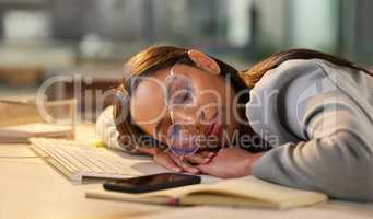 Nope, not tonight. Shot of a young businesswoman sleeping at her desk in a modern office.