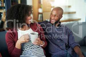 The weekend is the perfect time for quality time. Shot of a happy young couple enjoying a relaxing coffee break together on the sofa at home.