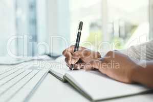 Write down your daily goals before you start each day. Cropped shot of an unrecognizable businesswoman writing in her notebook while sitting at her desk.