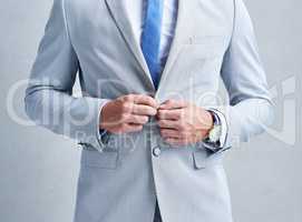 Theres no such thing as a second impression only first. Studio shot of a businessman in a grey suit posing against a grey background.