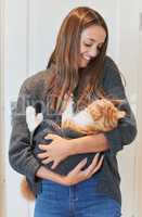 I just want to be a stay-at-home cat mom. Shot of a young woman carrying her cat at home.