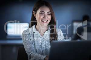 Her dedication clearly shows. Shot of a young businesswoman working on a laptop in an office at night.