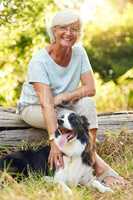 The perfect companion for retirement. Portrait of a happy senior woman relaxing in a park with her dog.
