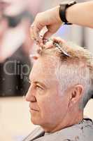 Im just here for a trim. Shot of a mature man getting a haircut in a salon.