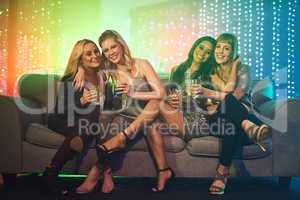 Tonight is reserved for the ladies. Shot of a group of friends having drinks on a sofa at a party.