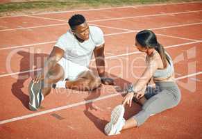 Theyre warming up to the task. High angle shot of a young athletic couple warming up before starting their outdoor exercise routine.